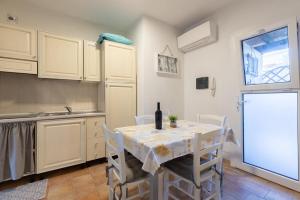 a kitchen with a table with a bottle of wine at Sibilla house 2 in Olbia
