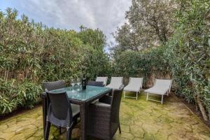 a table and chairs on a patio with trees at Sibilla house 2 in Olbia