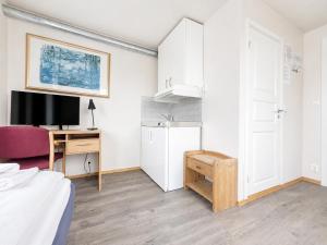 a bedroom with a bed and a desk with a tv at Hotel Toranes in Mo i Rana