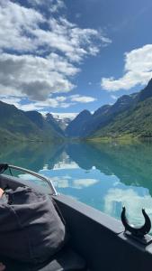 a boat on a body of water with mountains at Olden Camping in Olden