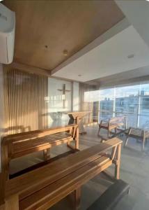 a room with two wooden benches and a table at Cozy Loft Studio with Balcony in Cebu City in Cebu City