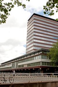 a man riding a bike in front of a building at MAX Hotel Amsterdam in Amsterdam