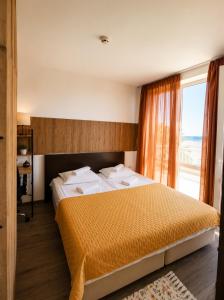 a bedroom with a large bed and a window at Atlantis Resort Sea View in Burgas