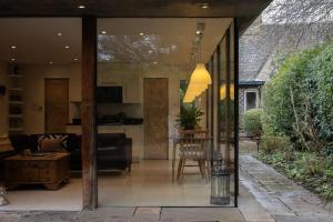 a glass extension of a house with a living room at The Nook in South Cerney