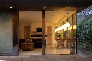 a living room and dining room with glass walls at The Nook in South Cerney