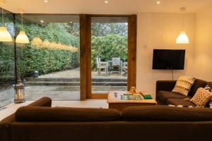 a living room with a couch and a tv at The Nook in South Cerney