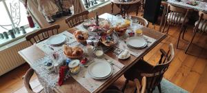 a table with plates and bowls of food on it at B&B Petit Chateau - Rust en Charme Nabij Gent, Brugge en de Zeeuwse kust in Biervliet