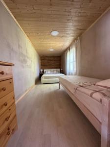 a bedroom with two beds and a wooden ceiling at Metsatoa in Alliklepa