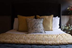 a bed with a bunch of pillows on it at The Nook in South Cerney