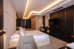 ein Schlafzimmer mit einem weißen Bett und einem Schreibtisch in der Unterkunft Hotel Chicago in Shkodra