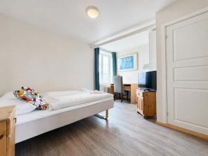 a white room with a bed and a television at Hotel Toranes in Mo i Rana