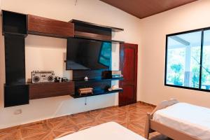 a room with a flat screen tv on a wall at Finca La Macarena, Playas Villamil in Playas