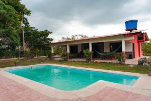 a house with a swimming pool in front of it at Finca La Macarena, Playas Villamil in Playas