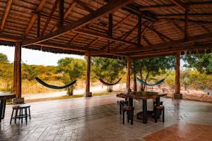 a pavilion with hammocks and a table and chairs at Finca La Macarena, Playas Villamil in Playas