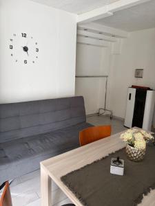 a living room with a couch and a clock on the wall at Appartamento Camponovo in Chiasso