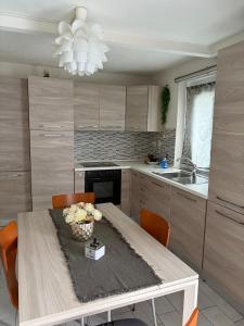 a kitchen with a wooden table with chairs and a sink at Appartamento Camponovo in Chiasso