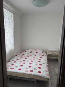 a bedroom with a bed with red flowers on it at Appartamento Camponovo in Chiasso