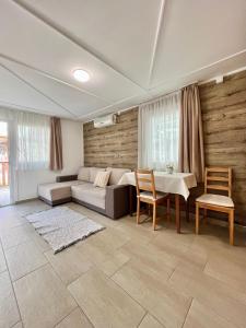 a living room with a couch and a table and chairs at Harmónia faházak in Bogács