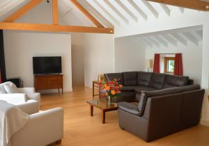 a living room with a couch and a tv at Rural Cottage Retreat, Near Goodwood Festival of Speed, Dog Friendly with Shared Outdoor Pool, gardens & Tennis, Free Parking! Chichester Holiday Properties in North Mundham