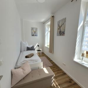 a white living room with a couch and a window at Ferienwohnung Ramona in Sonneberg
