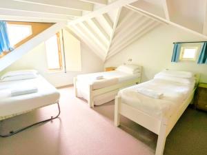 a room with three beds in a attic at Rural Cottage Retreat, Near Goodwood Festival of Speed, Dog Friendly with Shared Outdoor Pool, gardens & Tennis, Free Parking! Chichester Holiday Properties in North Mundham +26 photos