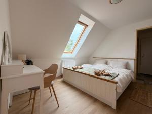 a bedroom with a bed with a desk and a window at Búda u Totevú in Skalica