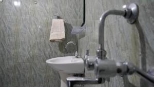 a bathroom with a white sink and a toilet at Summer Guest House in Chauntrā