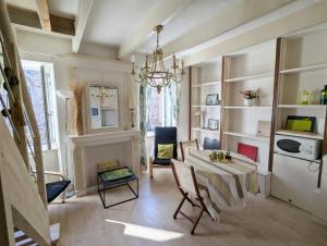 a living room with a table and chairs and a chandelier at Appartement cosy - au cœur du bourg in Crozon
