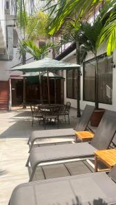a patio with a table and chairs and a umbrella at Hotel Patrimonial by Greenfield in Guayaquil