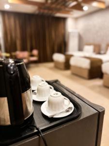 a black counter with three cups and a tea kettle at Ward Hotel Basra in Al Başrah