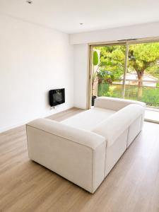 a white living room with a white couch and a tv at Cosy Flat Cannes in Le Cannet +12 photos