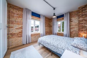 a bedroom with a bed and a brick wall at H7 Stuudiokodud- SELF CHECK-IN in Viljandi