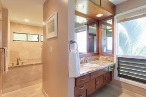 a bathroom with a sink and a large mirror at 411 Ridge in Kahana