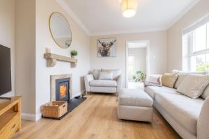 a living room with a couch and a fireplace at Coolbuck Cottage in Lisbellaw