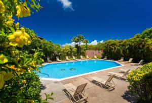 a swimming pool with lounge chairs and a resort at 411 Ridge in Kahana +32 photos