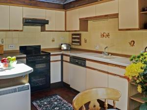a kitchen with a sink and a stove top oven at Forge Mill Cottage in Dalbeattie