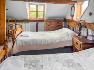 a bedroom with two beds and a wooden dresser at Stocks Tree Cottage in Preston Wynne