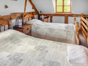 a bedroom with two beds and a window at Stocks Tree Cottage in Preston Wynne +6 photos
