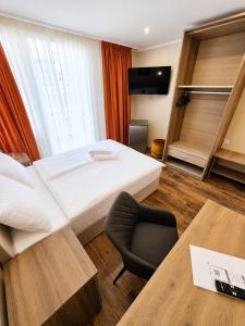 a hotel room with a bed and a chair at Hotel Post Nürtingen in Nürtingen