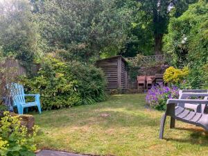 a yard with two blue benches and flowers at St James Cottage in Shaftesbury