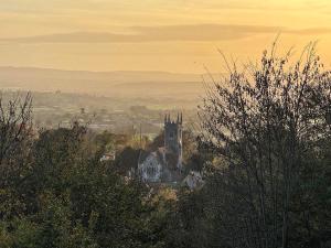 an old building on top of a hill with trees at St James Cottage in Shaftesbury