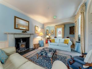 a living room with two couches and a fireplace at Kilmichael House in Brodick