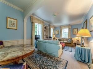 a living room with a couch and a table at Kilmichael House in Brodick
