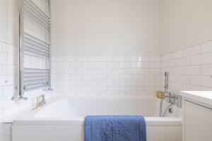 a white bathroom with a tub and a blue towel at Coolbuck Cottage in Lisbellaw +33 photos