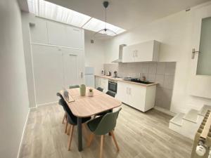 a kitchen with a table and chairs in a room at L'Apart Amiens in Le Treuil