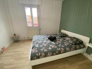 a bedroom with a bed with a teddy bear on it at L'Apart Amiens in Le Treuil