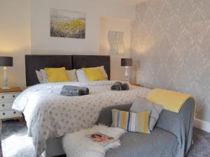 a bedroom with a large bed and a couch at Sonny Cottage in Glanamman +13 photos