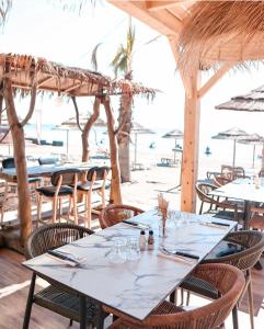a restaurant with tables and chairs on the beach at Residence Marea Resort in Santa-Lucia-di-Moriani