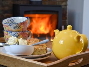 a tray with a tea pot and a plate of food at Three Creeks Cottage in Portknockie