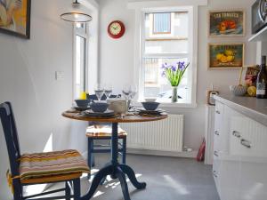 a kitchen with a table with wine glasses on it at Three Creeks Cottage in Portknockie